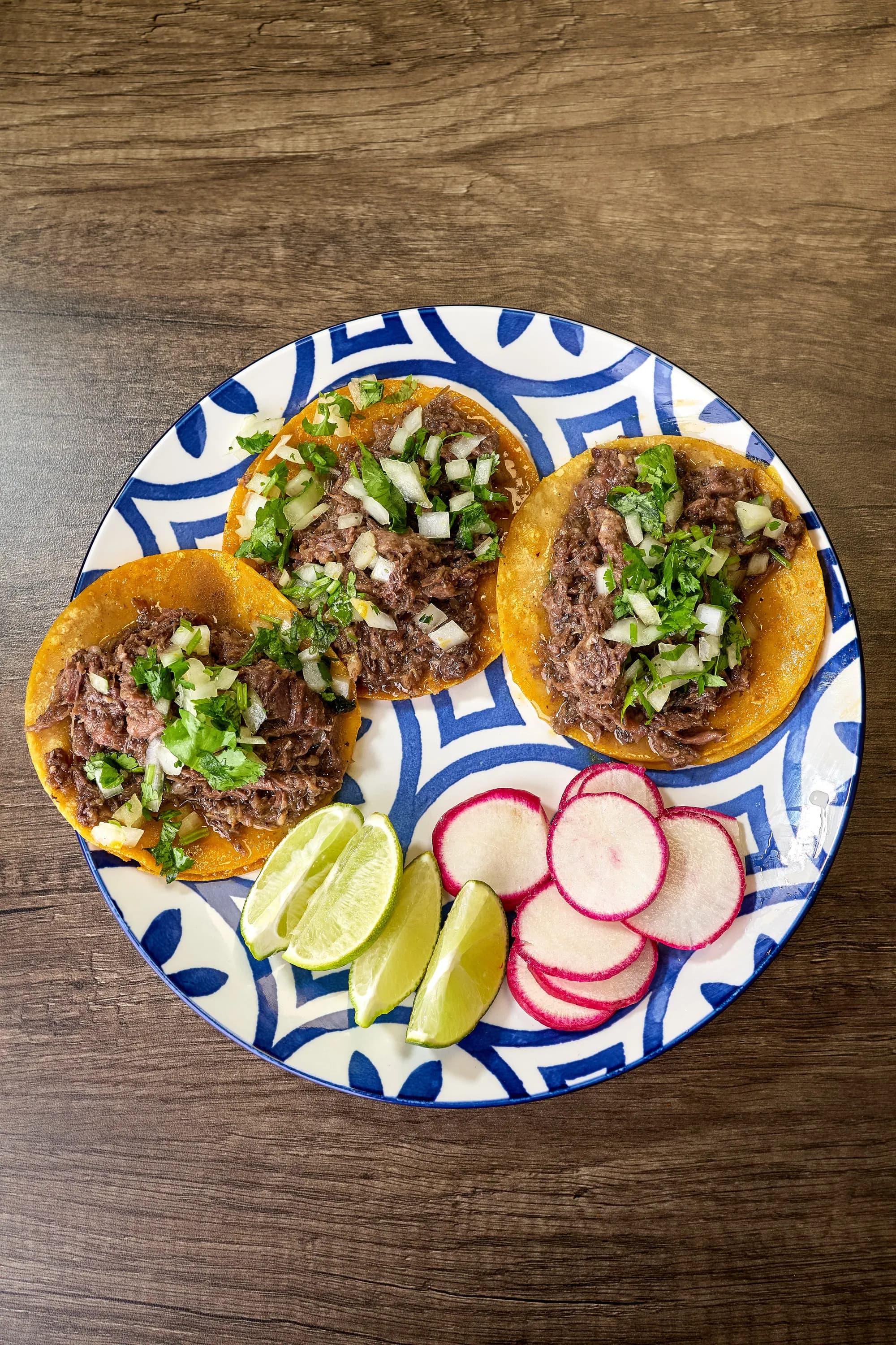 Plate of beef birria tacos with consommé at Mr. Birria